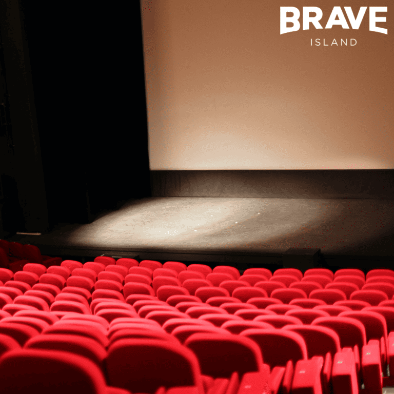 an image of red seats and a stage in an empty theatre