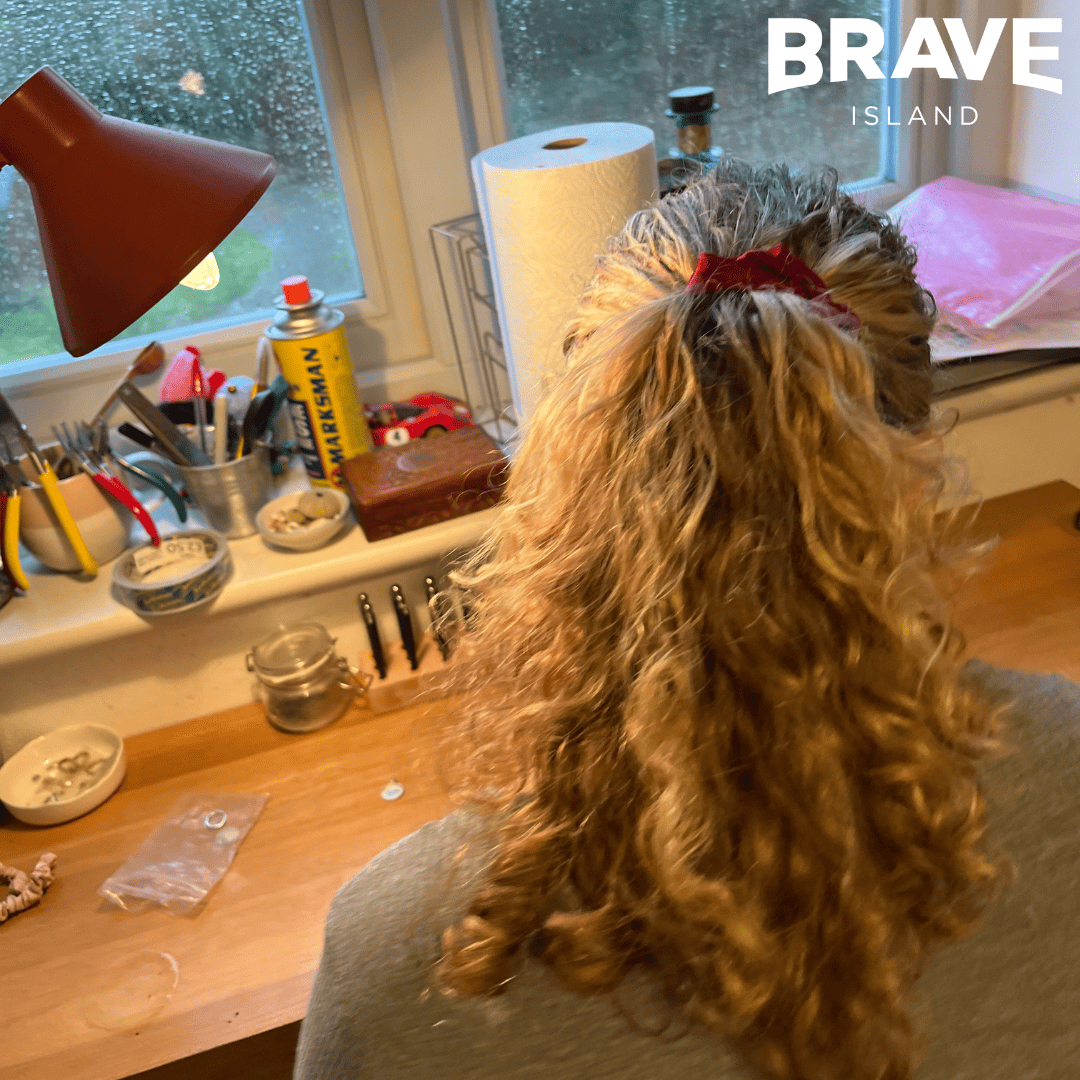 Ruby is sat at a desk with her long curly hair tied back