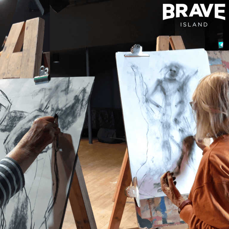 two people at a life drawing class, drawing a figure on easels in charcoal