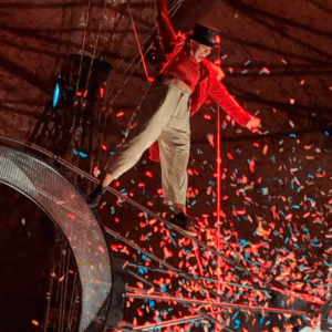 Image of a circus performer in the air surrounded by confetti