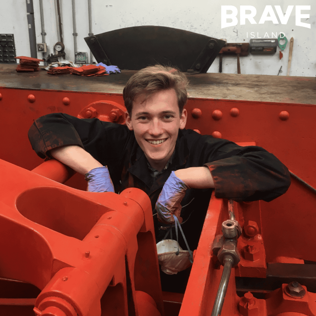 a young person smiling working on a steam train