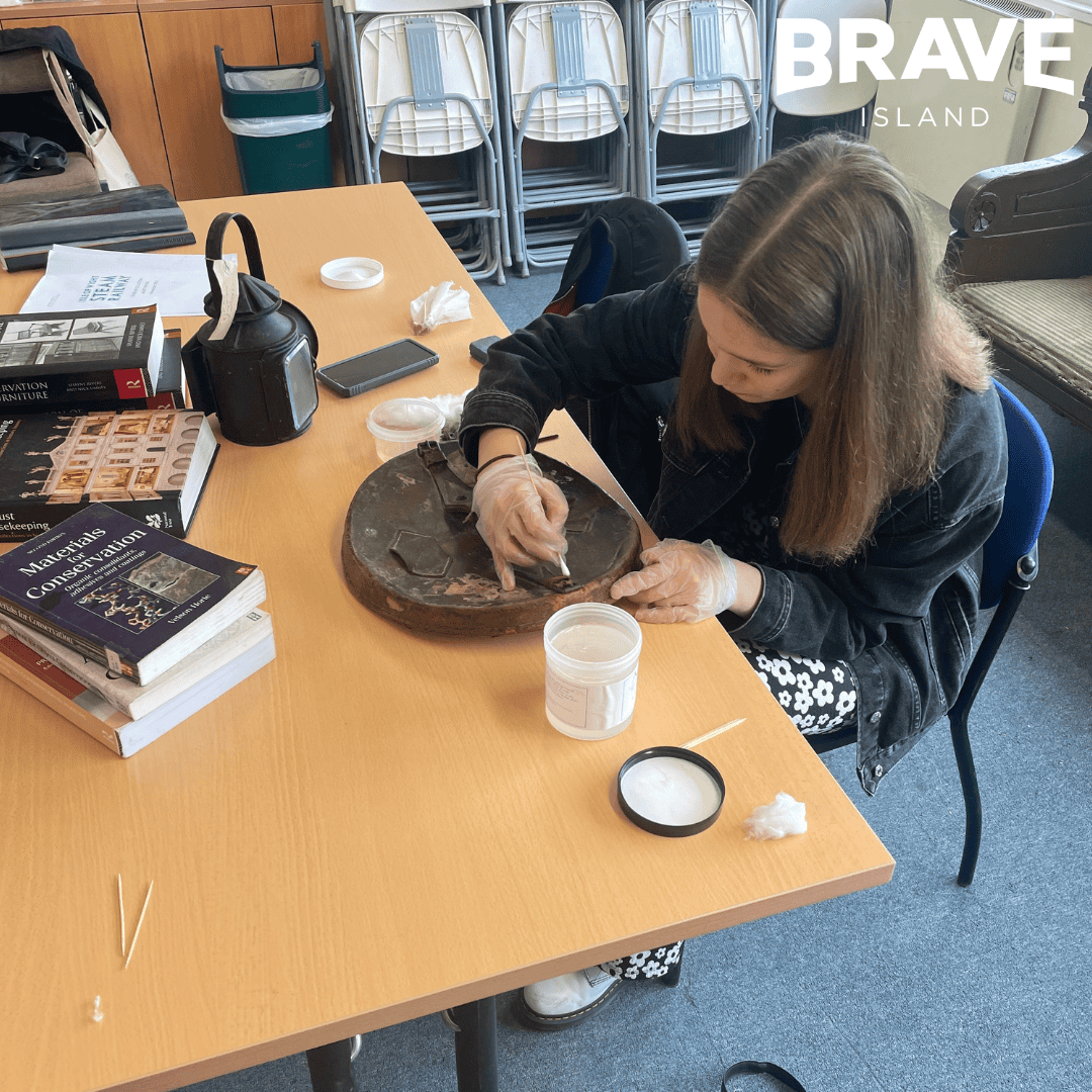 A young person is conserving a museum artefact