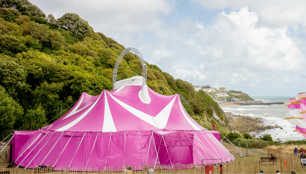 A photograph of the Ventnor Exchange Arena, a circus style big top. In the background you can see the sea at Ventnor, sle of Wight